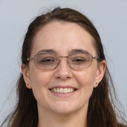 Joyful white adult female with long  brown hair and grey eyes