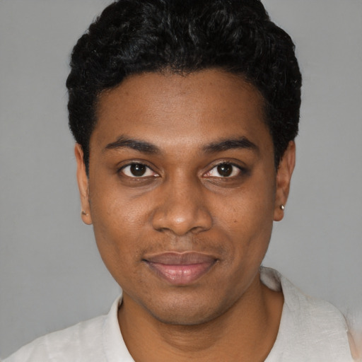 Joyful black young-adult male with short  black hair and brown eyes