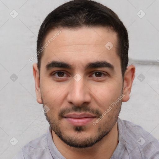 Joyful white young-adult male with short  black hair and brown eyes