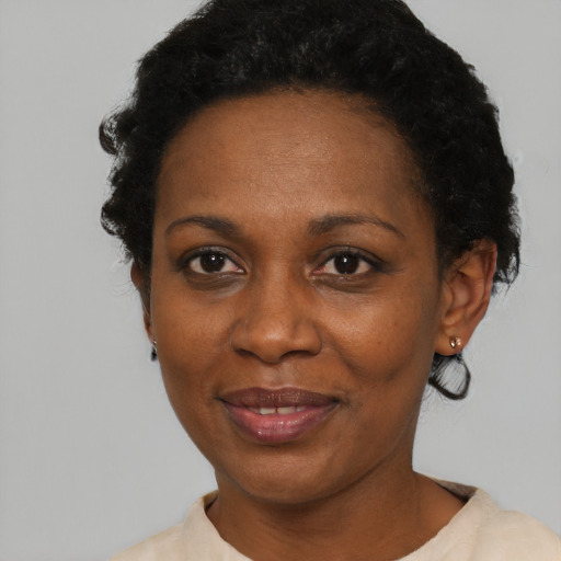 Joyful black adult female with short  black hair and brown eyes