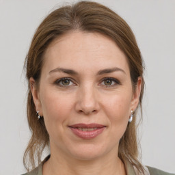 Joyful white adult female with medium  brown hair and grey eyes