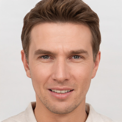 Joyful white young-adult male with short  brown hair and grey eyes