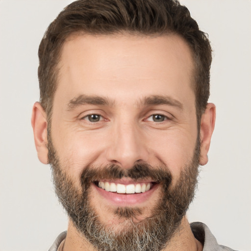 Joyful white adult male with short  brown hair and brown eyes