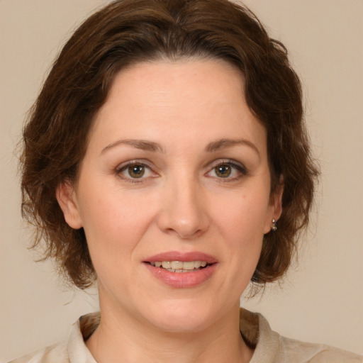 Joyful white young-adult female with medium  brown hair and green eyes