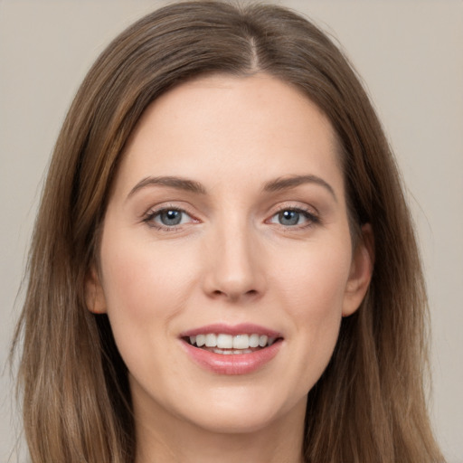 Joyful white young-adult female with long  brown hair and grey eyes