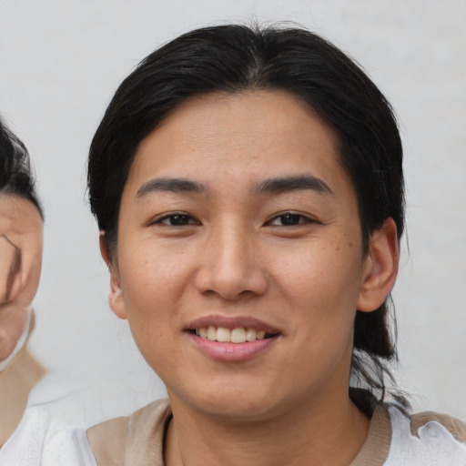 Joyful asian young-adult female with medium  black hair and brown eyes