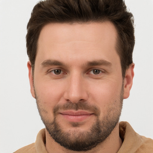 Joyful white young-adult male with short  brown hair and grey eyes