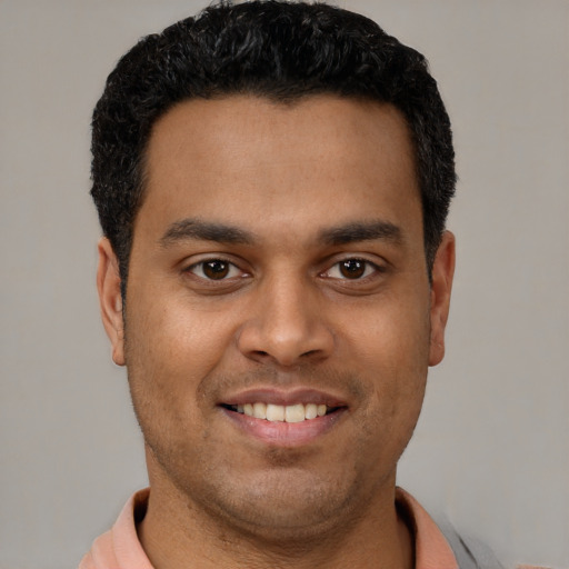 Joyful latino young-adult male with short  black hair and brown eyes