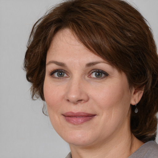 Joyful white adult female with medium  brown hair and grey eyes