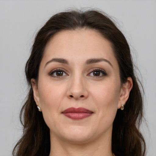 Joyful white adult female with long  brown hair and grey eyes