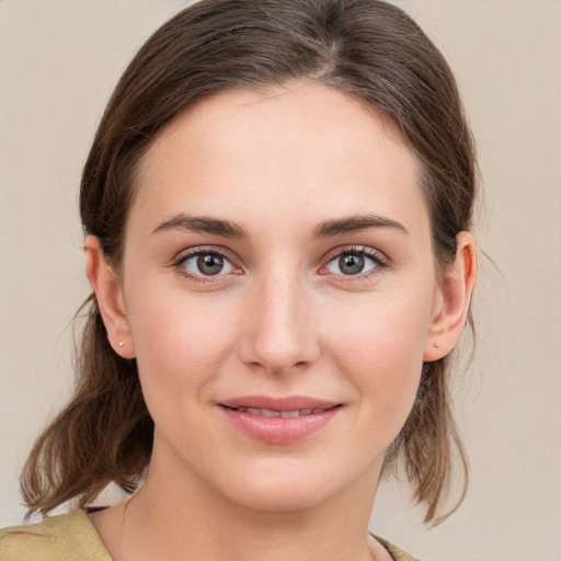 Joyful white young-adult female with medium  brown hair and grey eyes