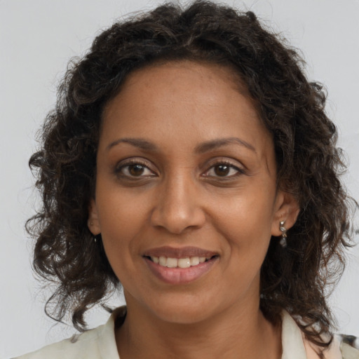 Joyful black adult female with medium  brown hair and brown eyes