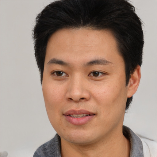 Joyful asian young-adult male with short  brown hair and brown eyes