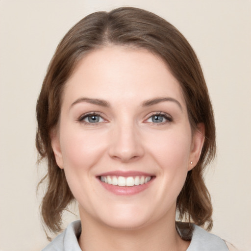 Joyful white young-adult female with medium  brown hair and blue eyes