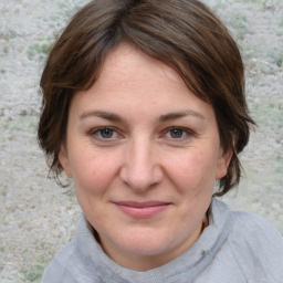 Joyful white young-adult female with medium  brown hair and blue eyes