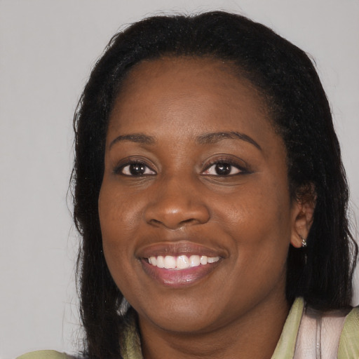 Joyful black young-adult female with long  black hair and brown eyes