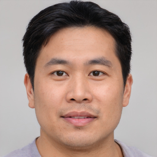 Joyful asian young-adult male with short  brown hair and brown eyes