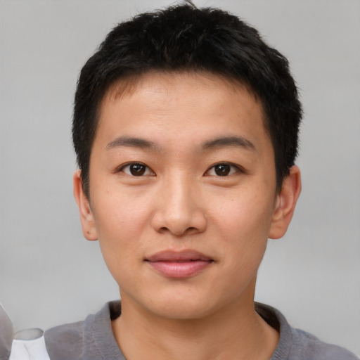 Joyful asian young-adult male with short  brown hair and brown eyes