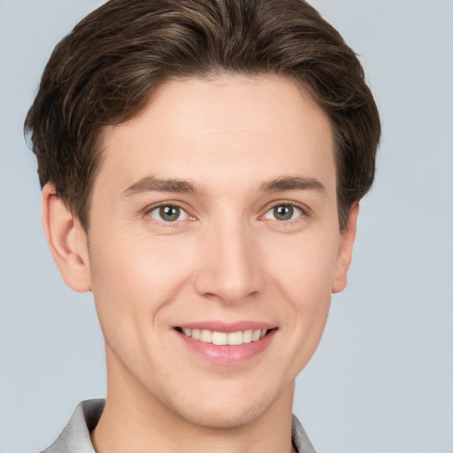 Joyful white young-adult male with short  brown hair and grey eyes