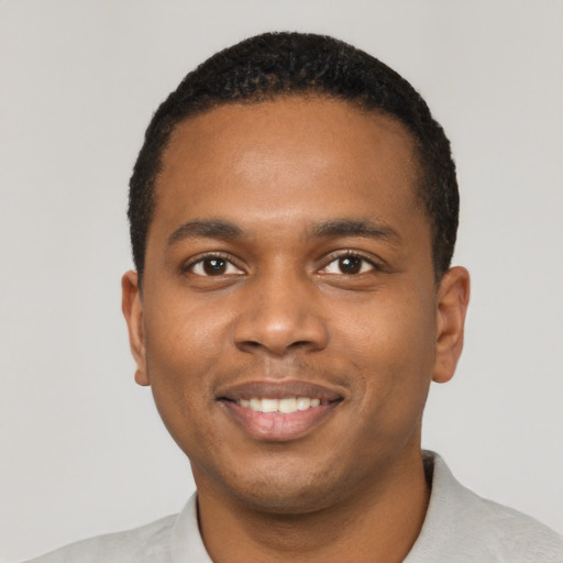 Joyful black young-adult male with short  black hair and brown eyes