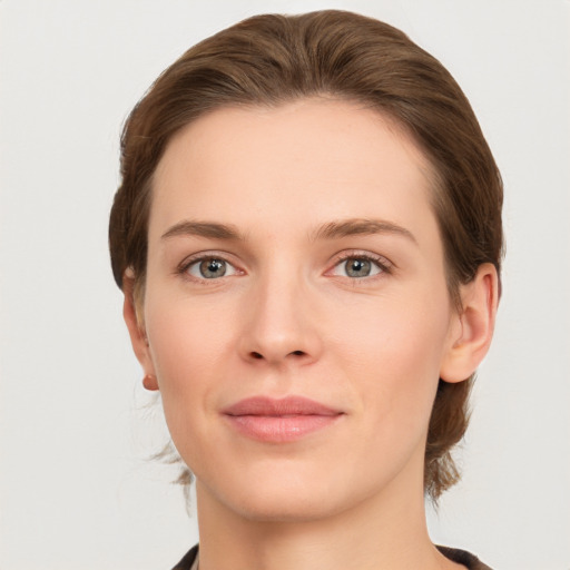 Joyful white young-adult female with medium  brown hair and grey eyes