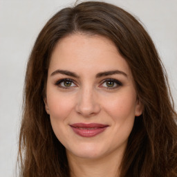 Joyful white young-adult female with long  brown hair and green eyes