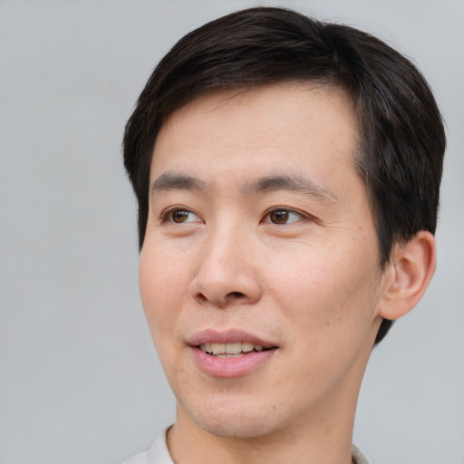 Joyful asian young-adult male with short  brown hair and brown eyes