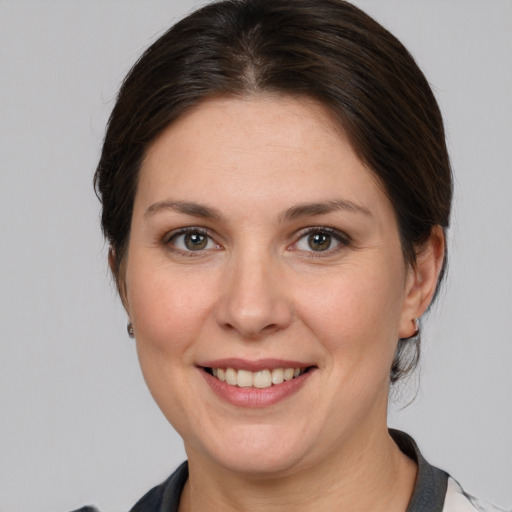 Joyful white young-adult female with medium  brown hair and grey eyes