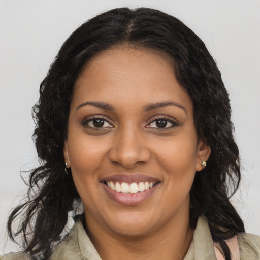 Joyful black young-adult female with long  brown hair and brown eyes