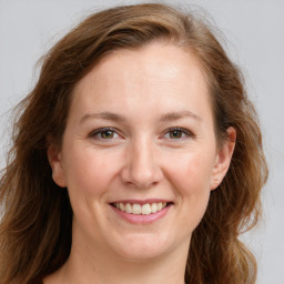 Joyful white young-adult female with long  brown hair and blue eyes