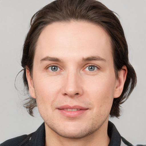 Joyful white young-adult male with medium  brown hair and grey eyes