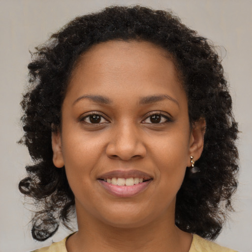 Joyful black young-adult female with medium  brown hair and brown eyes