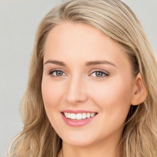 Joyful white young-adult female with long  brown hair and blue eyes