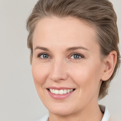 Joyful white young-adult female with medium  brown hair and grey eyes