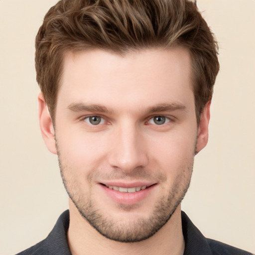 Joyful white young-adult male with short  brown hair and grey eyes