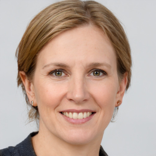 Joyful white adult female with medium  brown hair and grey eyes