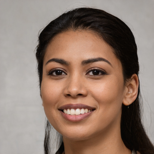 Joyful latino young-adult female with long  black hair and brown eyes