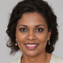 Joyful black adult female with medium  brown hair and brown eyes