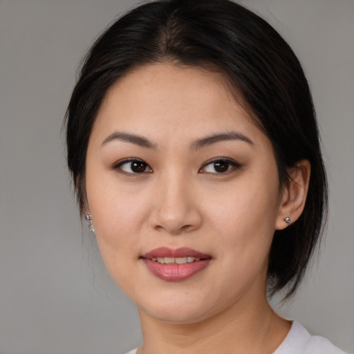 Joyful asian young-adult female with medium  brown hair and brown eyes