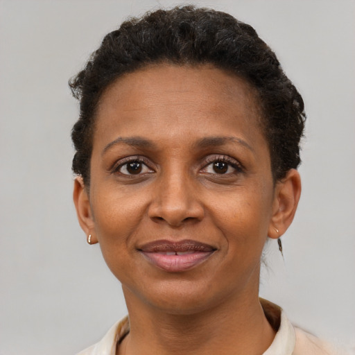 Joyful black adult female with short  brown hair and brown eyes