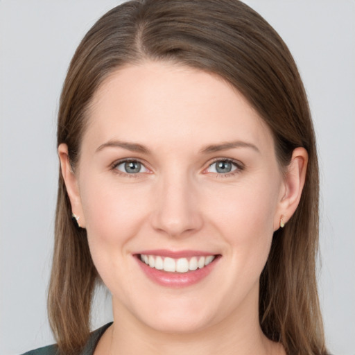 Joyful white young-adult female with long  brown hair and grey eyes