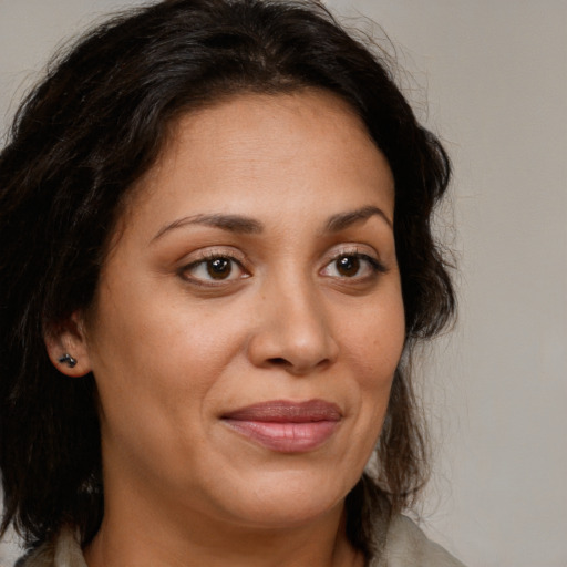 Joyful latino adult female with long  brown hair and brown eyes