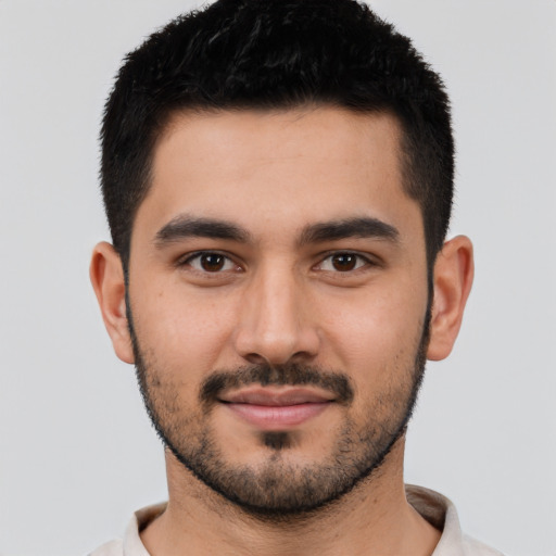 Joyful latino young-adult male with short  black hair and brown eyes