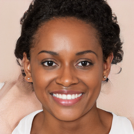 Joyful black young-adult female with long  brown hair and brown eyes