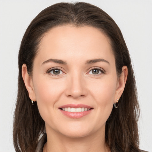 Joyful white young-adult female with long  brown hair and brown eyes