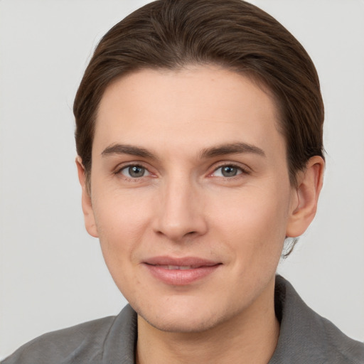 Joyful white young-adult male with short  brown hair and grey eyes