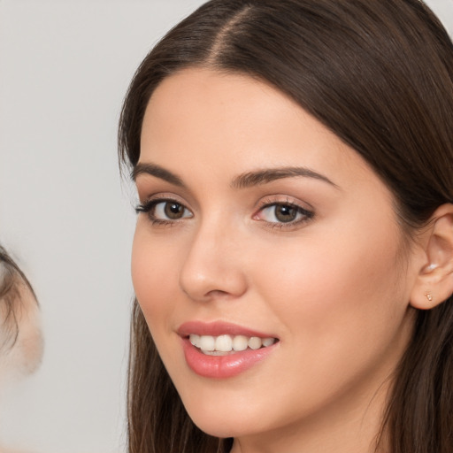 Joyful white young-adult female with long  brown hair and brown eyes