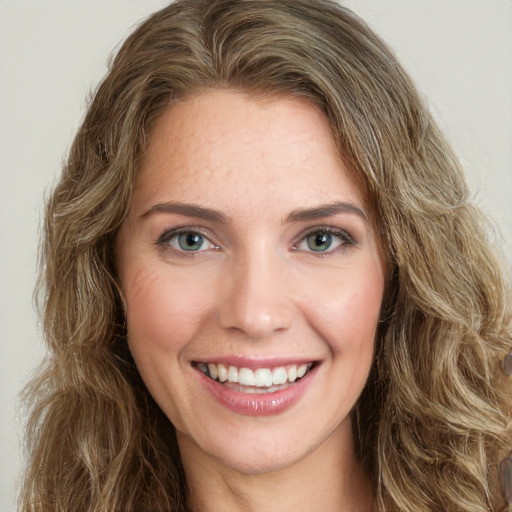 Joyful white young-adult female with long  brown hair and green eyes