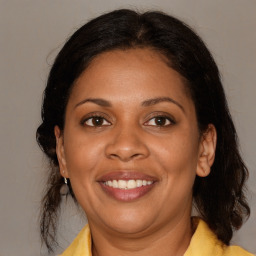 Joyful black adult female with medium  brown hair and brown eyes