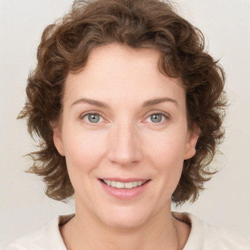 Joyful white young-adult female with medium  brown hair and blue eyes